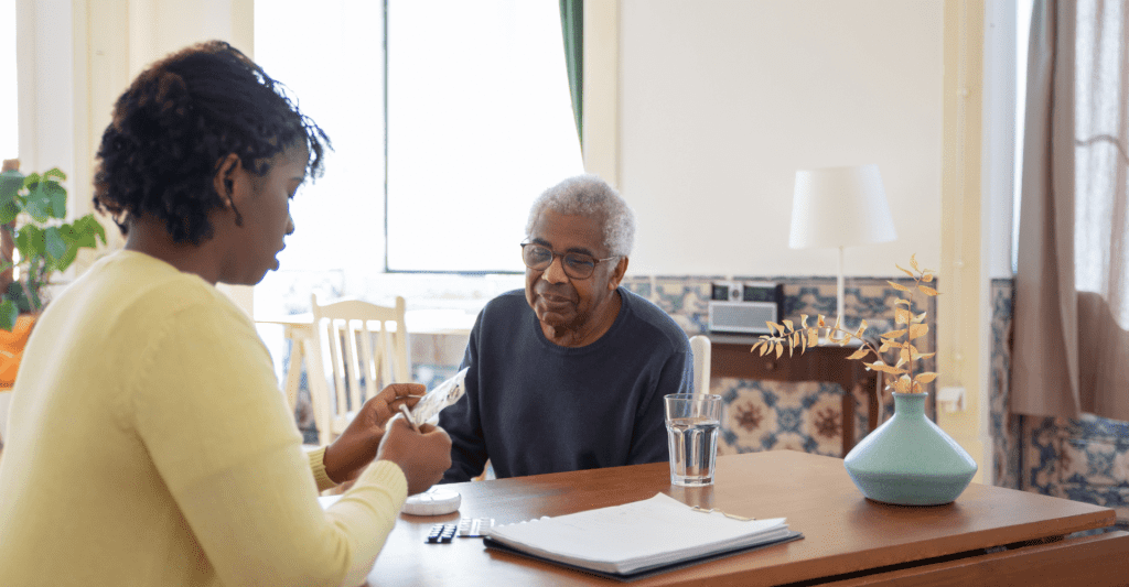 Daughter giving medication to her elder father