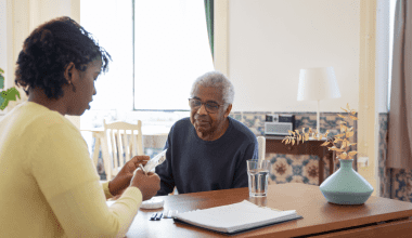 Daughter giving medication to her elder father