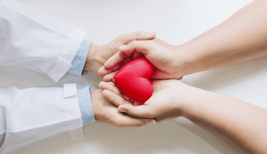 Holding hands with your doctor with heart in hands.