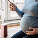 Pregnant woman holding phone