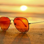 Sunglasses on a beach. Sunglasses can offer UV protection for your eyes.
