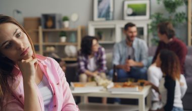 Woman sitting apart from a conversation